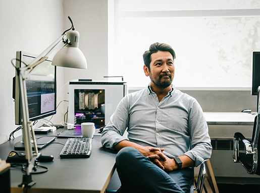 man sitting at desk smiling