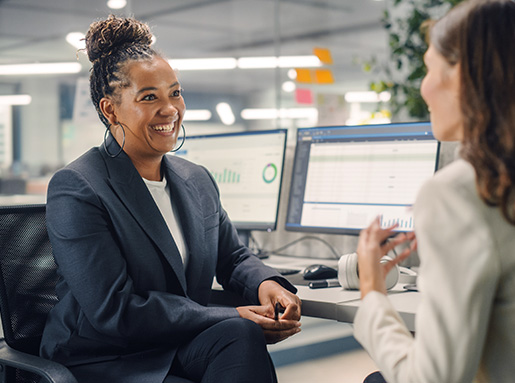 woman talking to teammate at desk